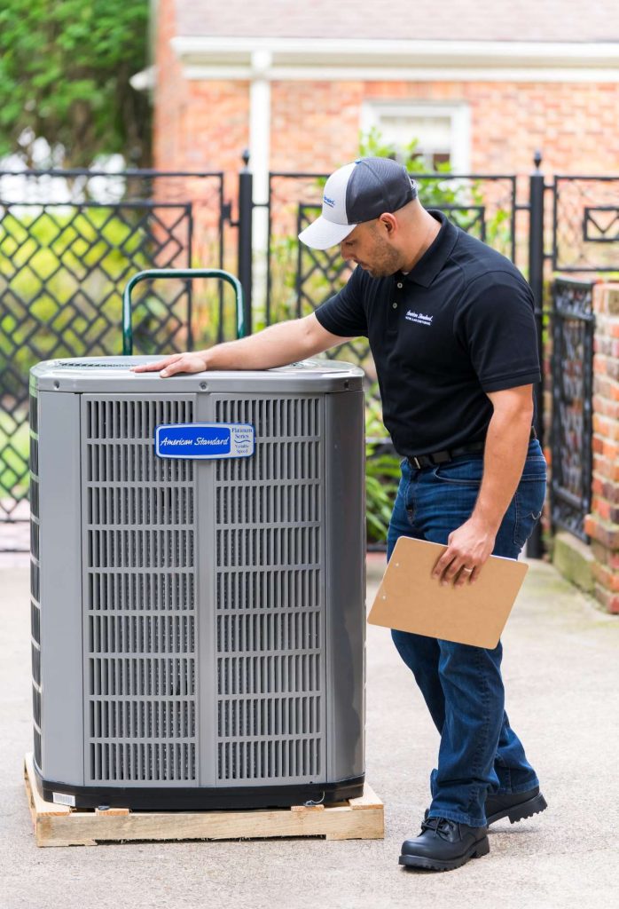 AC technician looking at an american standard hvac unit